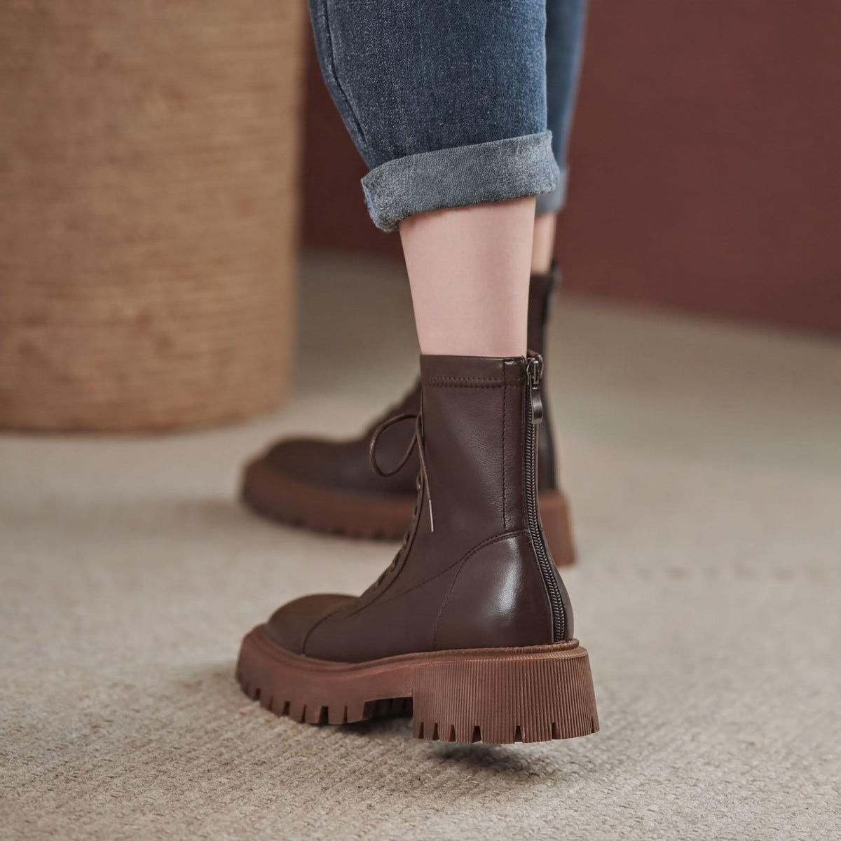 A close-up of a person's feet wearing brown leather boots with a chunky sole.