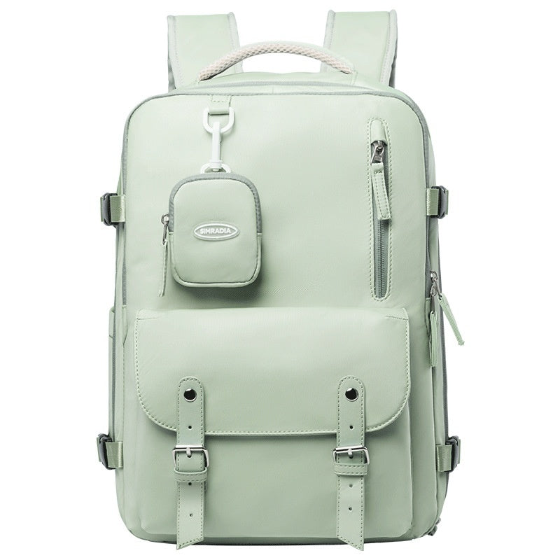 Front view of soft sage green travel backpack with detachable pouch and buckle-detail front pocket