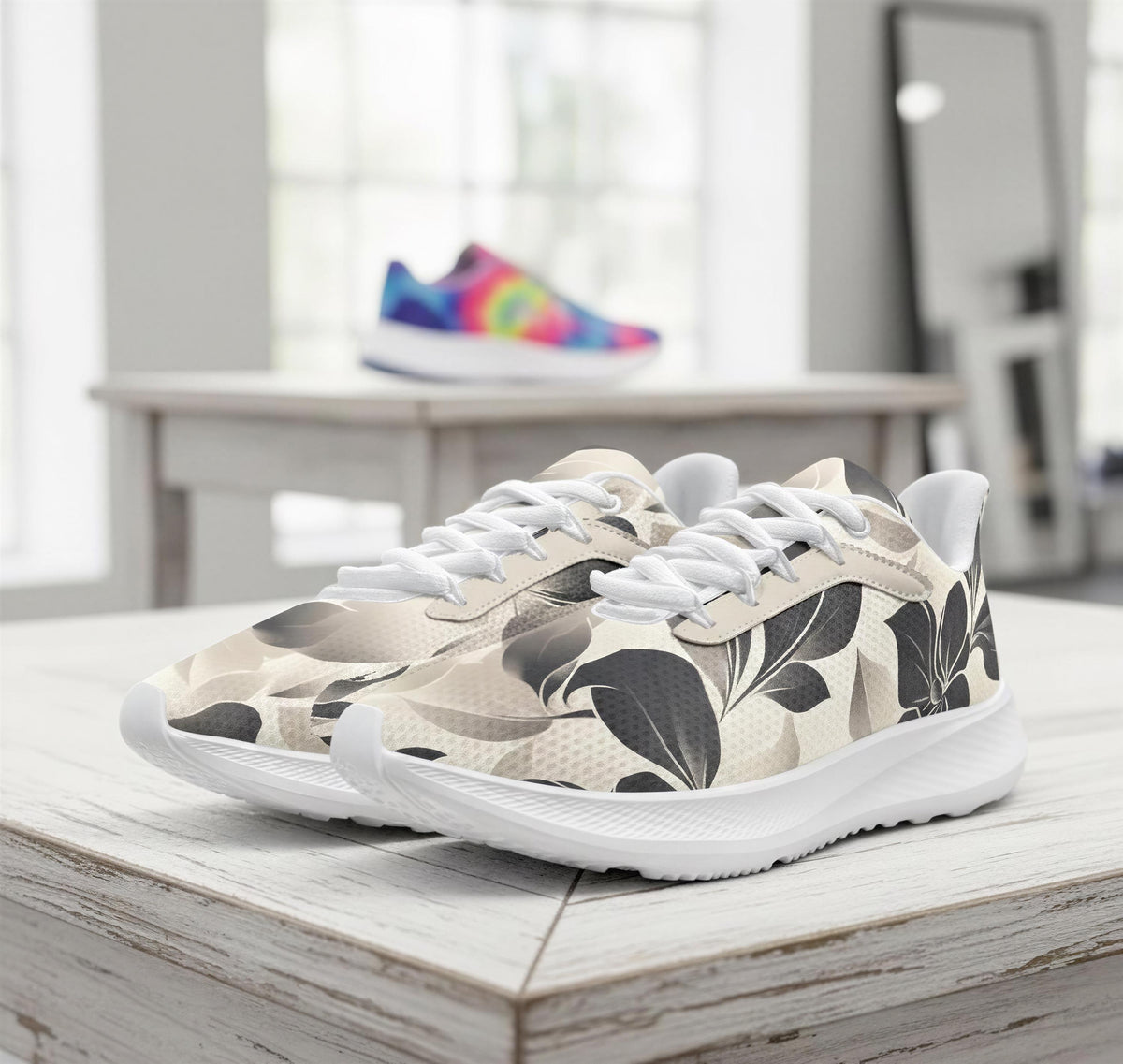 A pair of white sneakers with a floral pattern on the side, placed on a wooden surface.