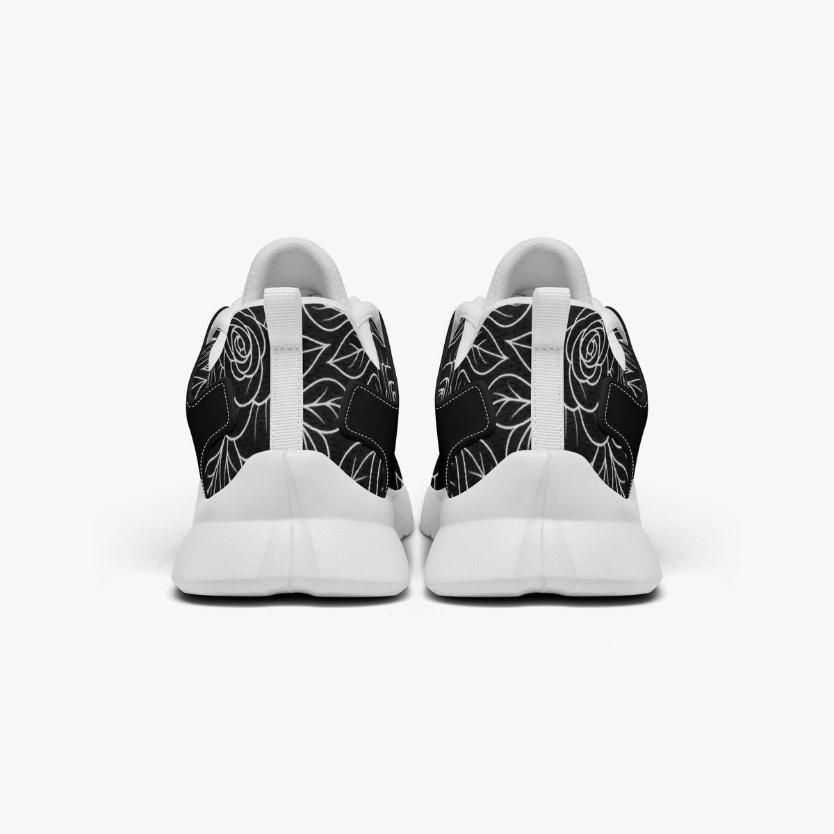 A pair of white sneakers with black floral designs on the back.
