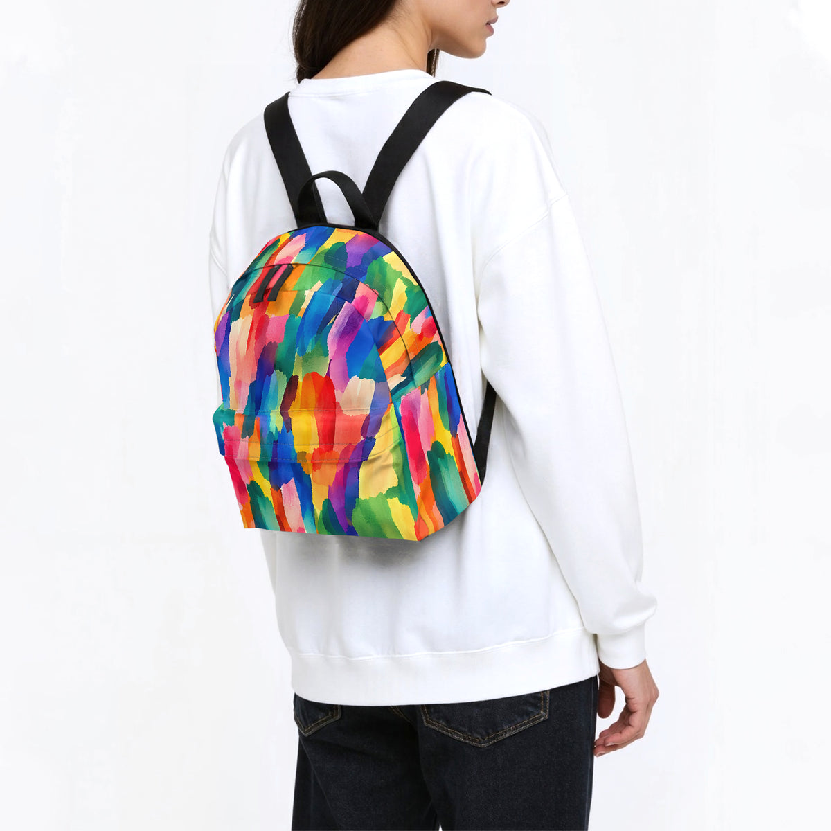 Woman in a white sweatshirt wearing a colorful backpack