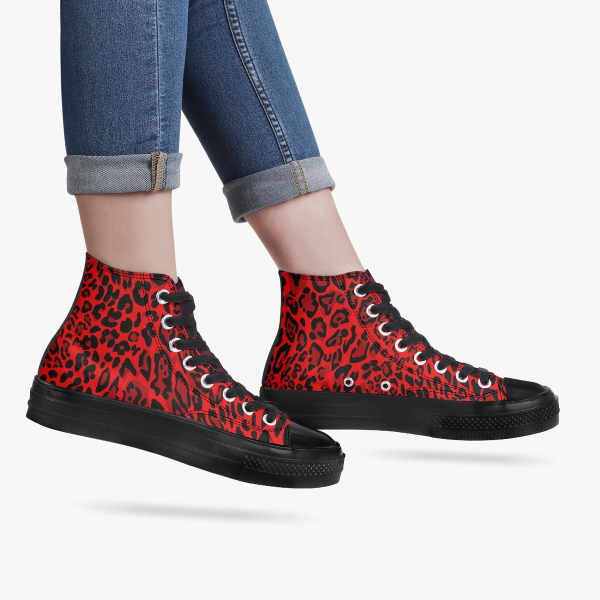 A pair of red and black leopard print sneakers with black soles and laces.