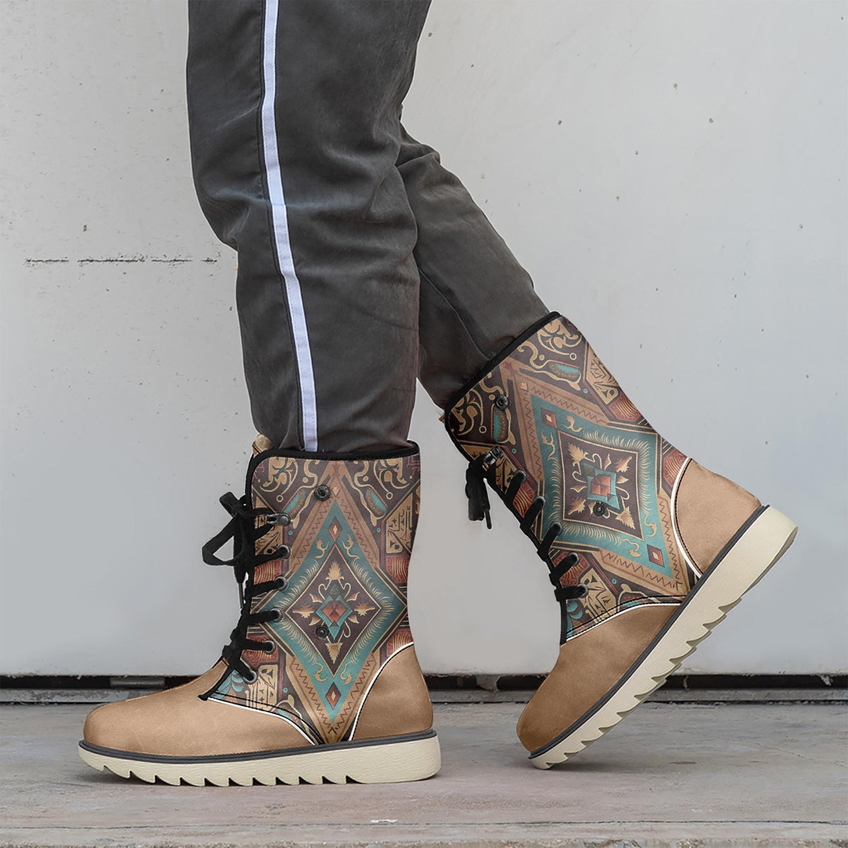 A person wearing tan and black patterned boots stands against a white wall.