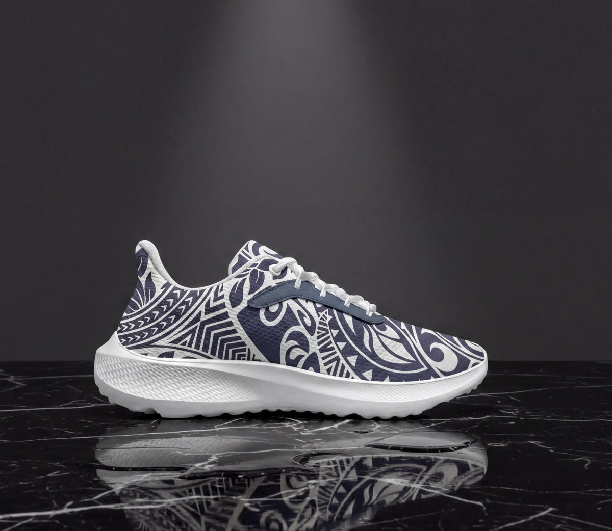 A white and blue patterned sneaker is displayed on a black marble surface, reflecting the image.