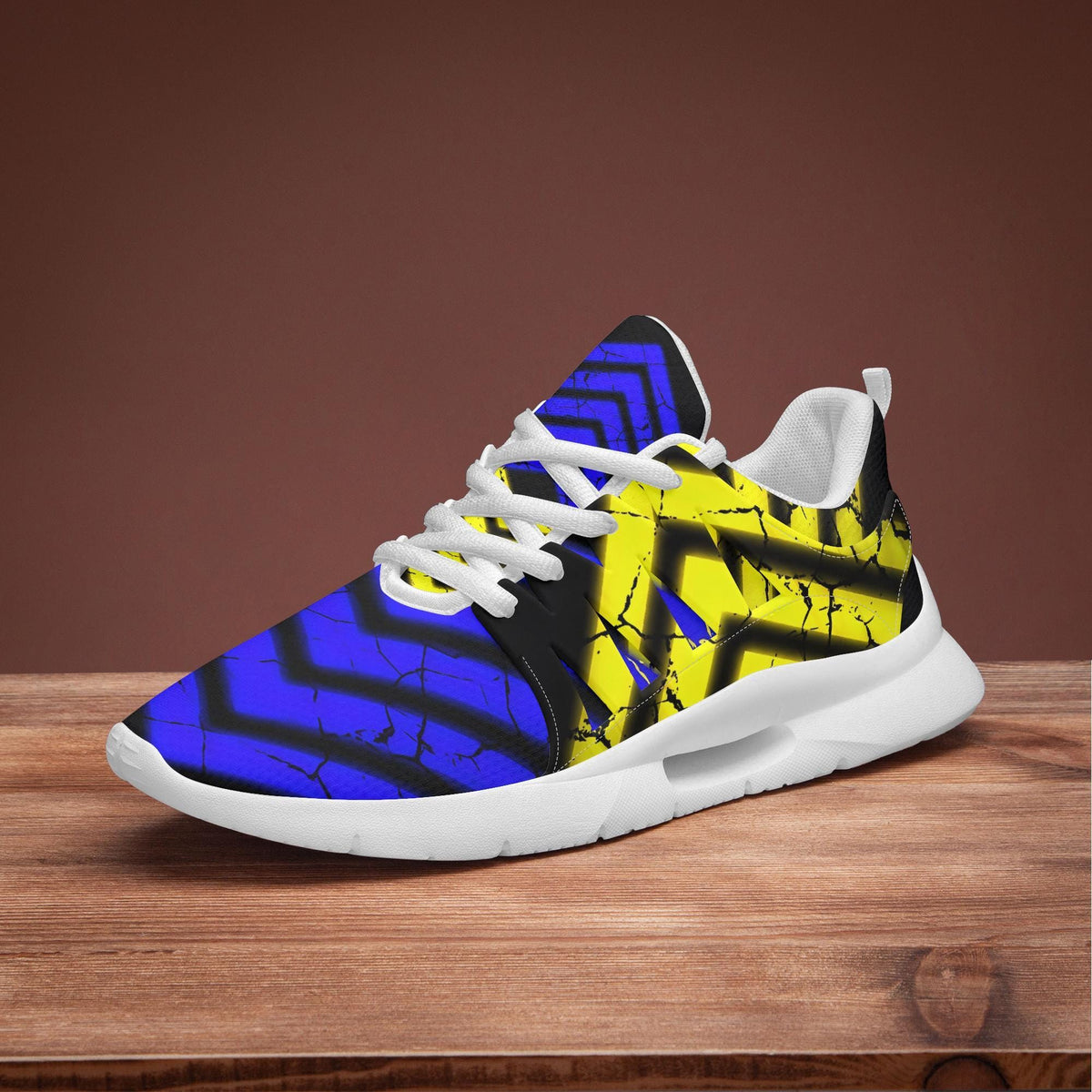 A colorful, patterned sneaker with blue and yellow stripes is displayed on a wooden surface.