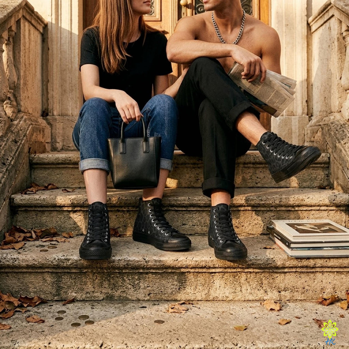 A shirtless man and a woman sitting on a set of stone steps, with the woman holding a black purse and the man reading a newspaper.