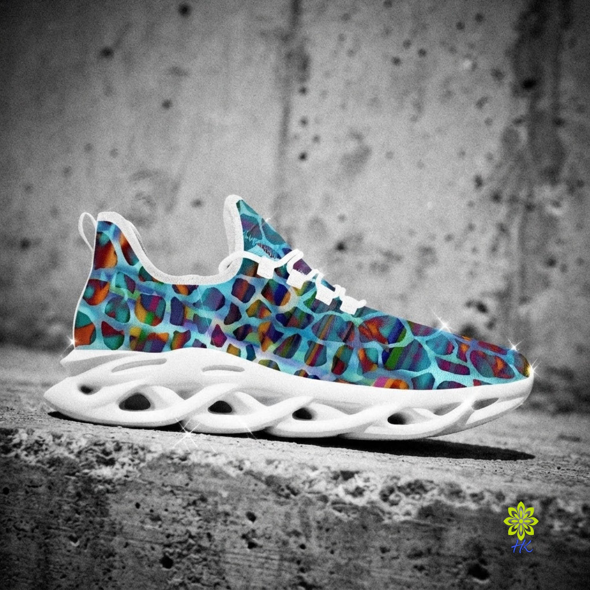 A single sneaker with a colorful abstract animal-print pattern in shades of blue, purple, red, and orange, paired with a thick white sculpted sole, shown on a concrete surface with a desaturated gray background.