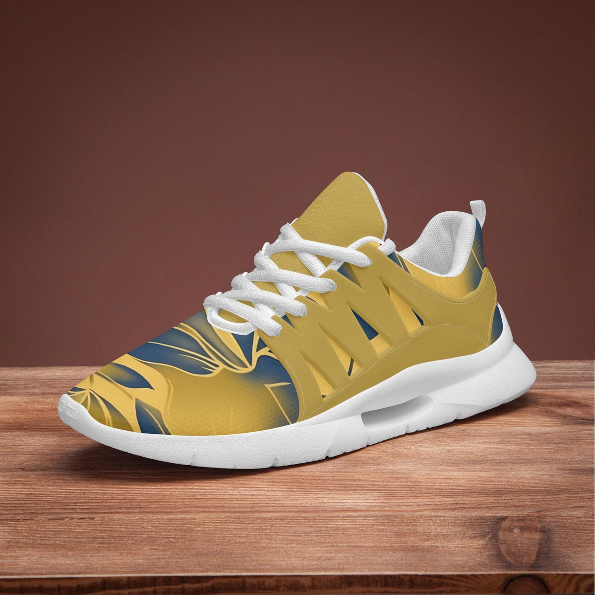 A yellow and white sneaker with a patterned design on a wooden surface.