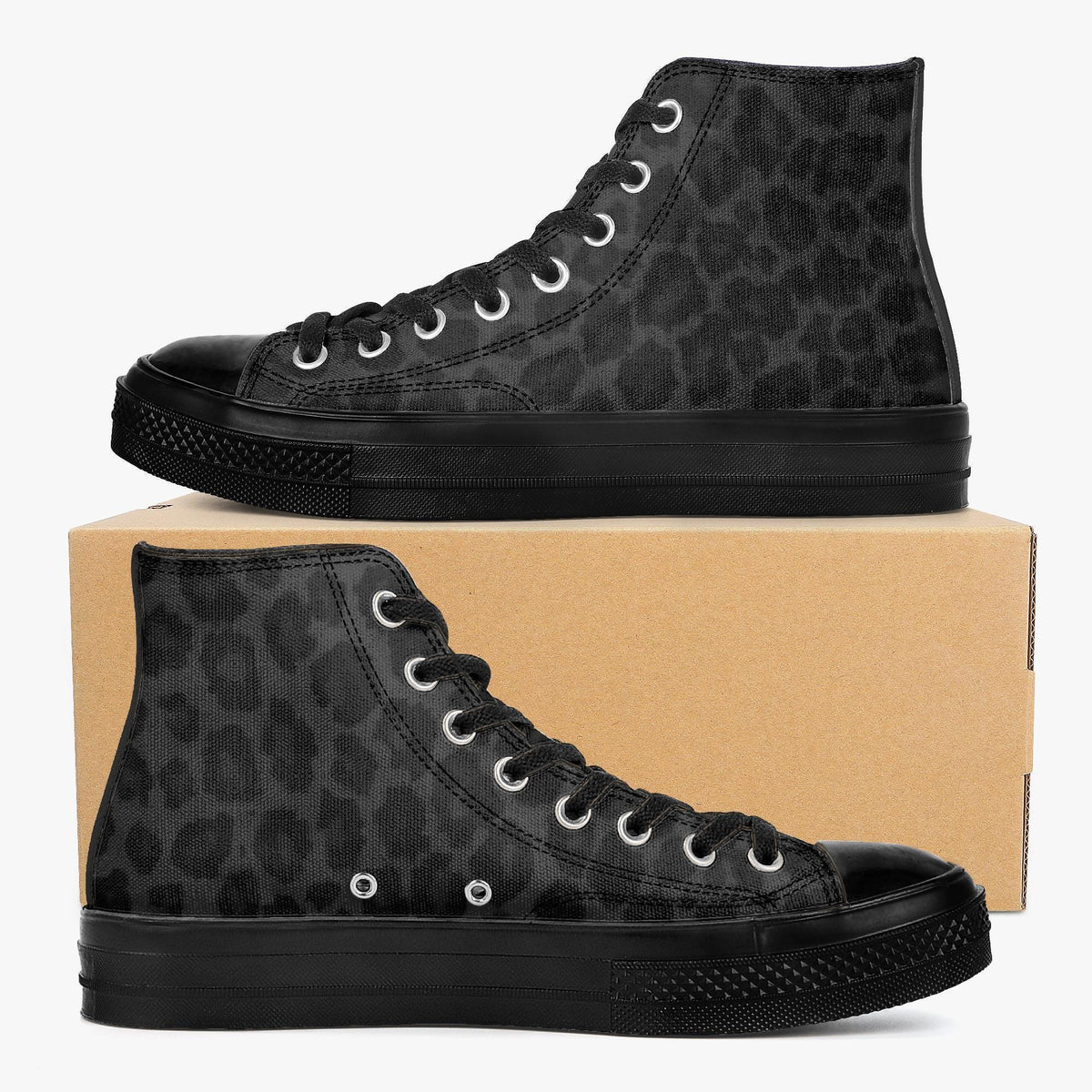 A pair of black high-top sneakers with a leopard print pattern, placed on top of a cardboard box.