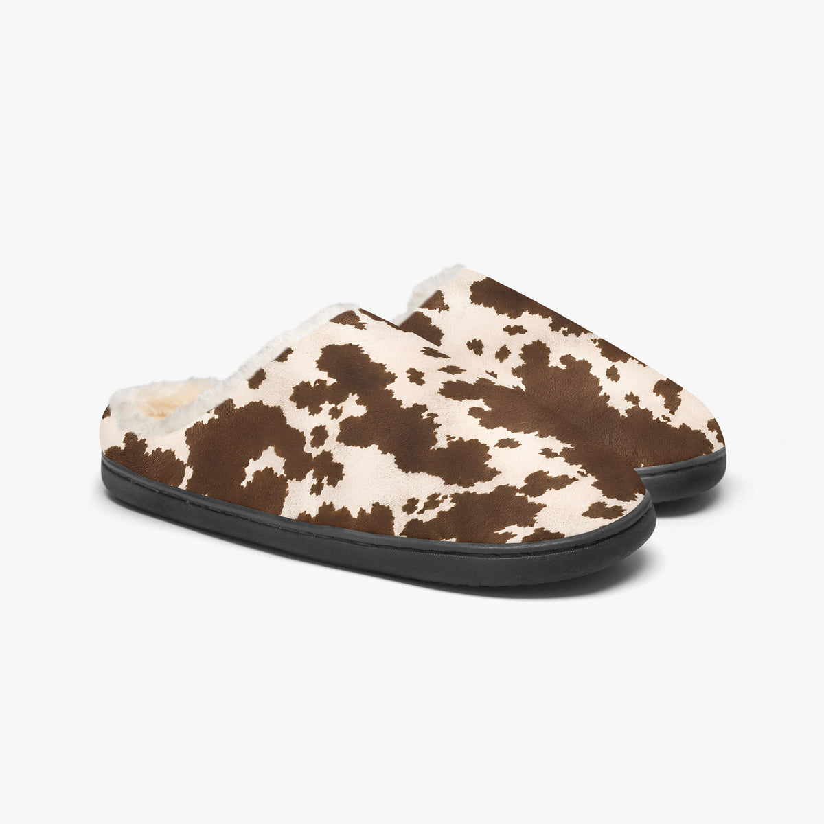 Par de zapatillas de casa de vaca sobre fondo blanco, vista lateral en ángulo