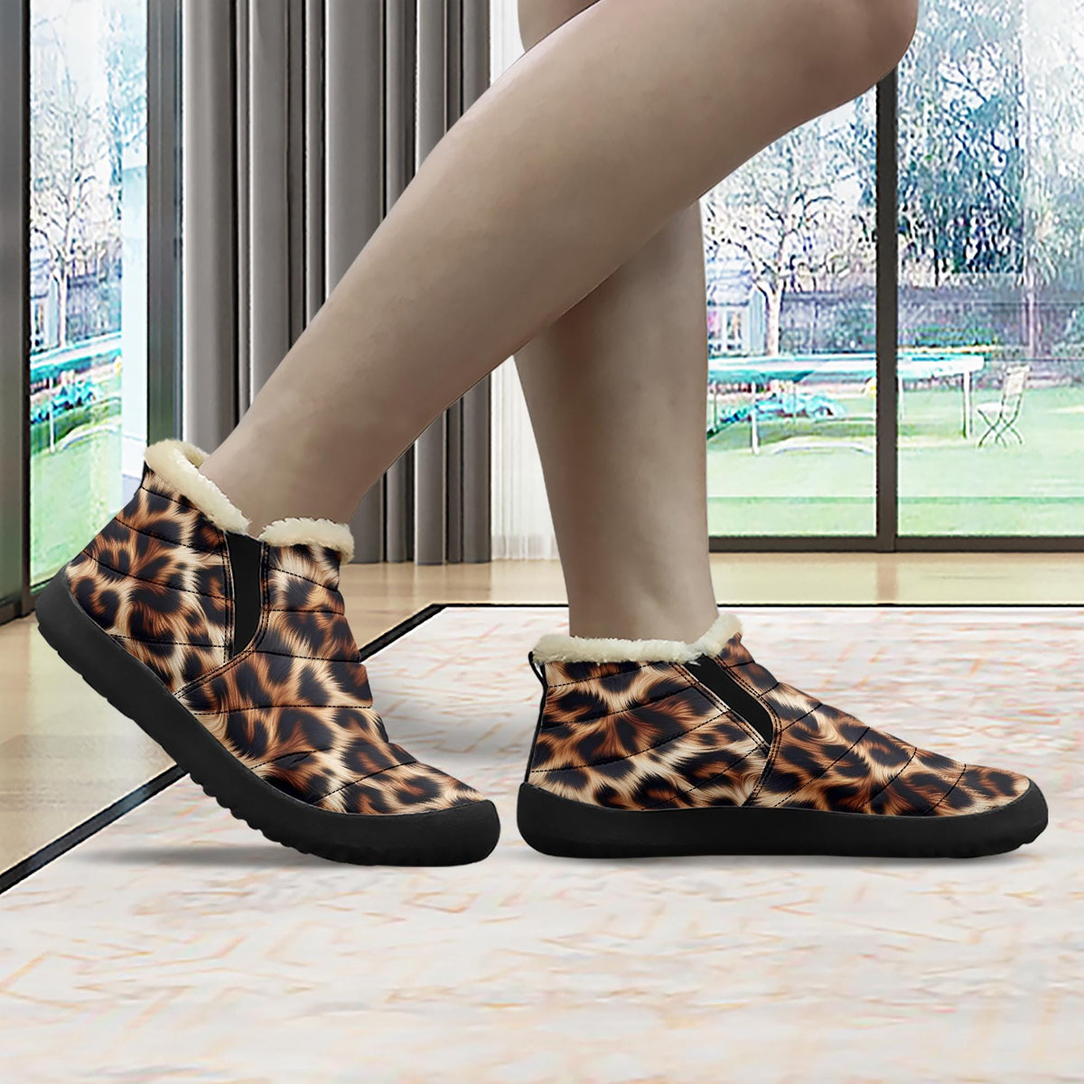 A person's feet wearing leopard print boots with fur trim, standing on a patterned rug in front of a window.