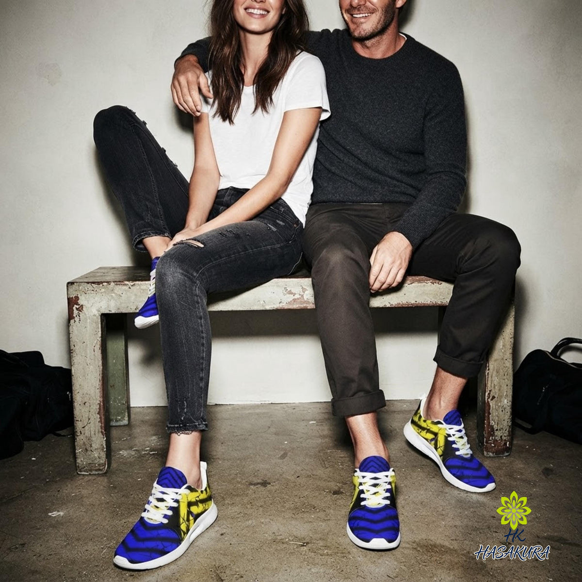 A man and a woman sitting on a bench, smiling and posing for the camera.