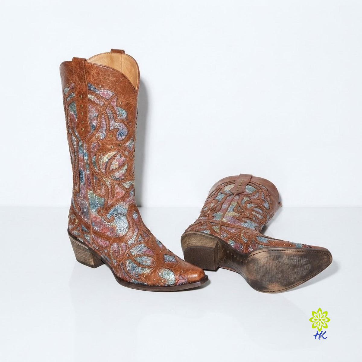 Pair of cowboy boots on a plain light background showing the sole and stacked heel