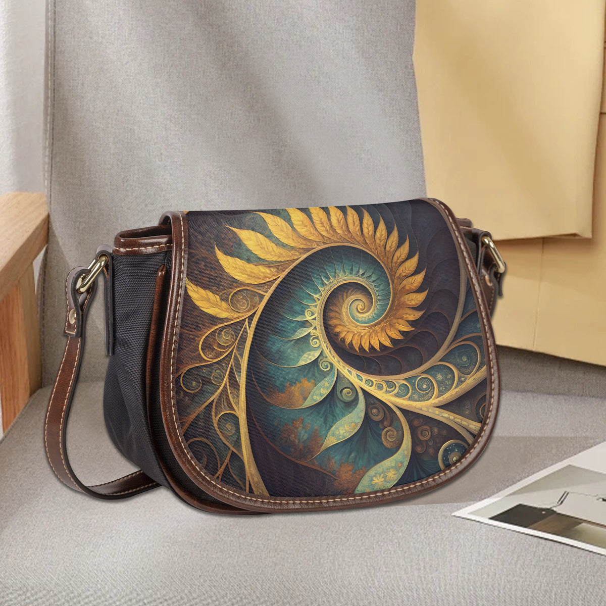 Saddle bag schoudertas op grijze stoel met zichtbare geprinte klep