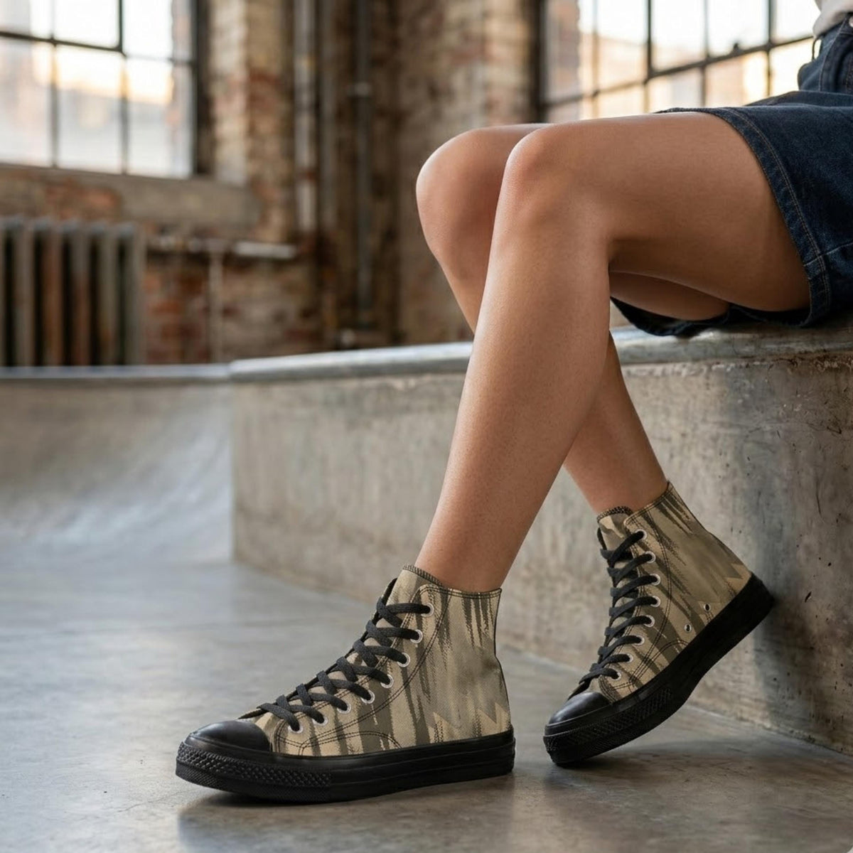 A person's legs wearing camouflage-patterned high-top sneakers are shown in a relaxed pose, with their feet resting on a concrete ledge.