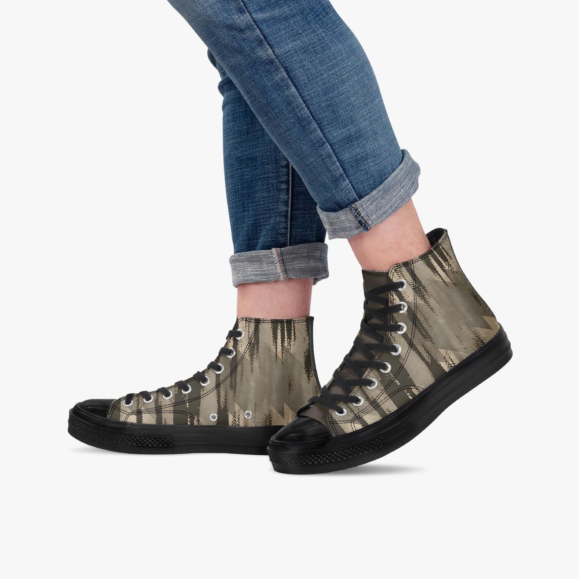 A person wearing blue jeans and black and gold patterned sneakers.