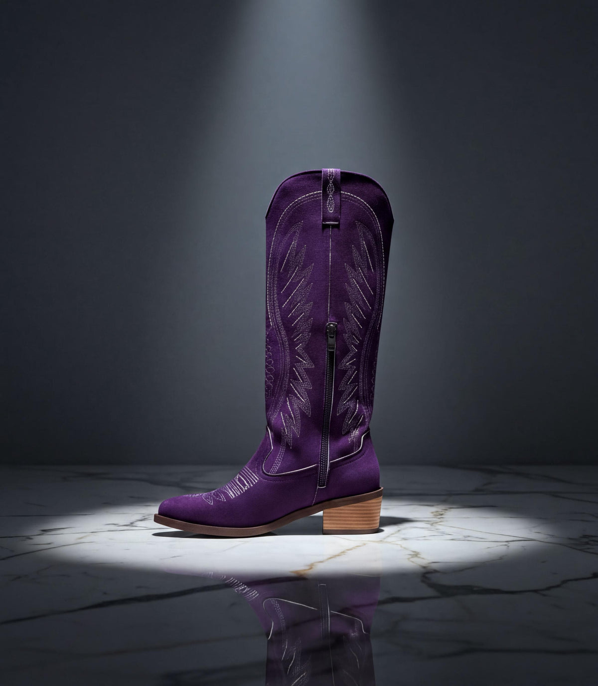 A purple cowboy boot is displayed on a marble floor, illuminated by a spotlight.