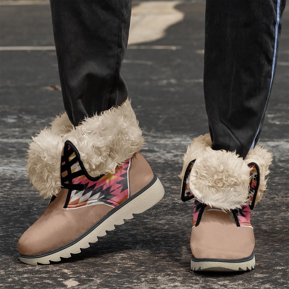A close-up of a person's feet wearing tan and pink boots with fur trim, standing on a gray pavement.