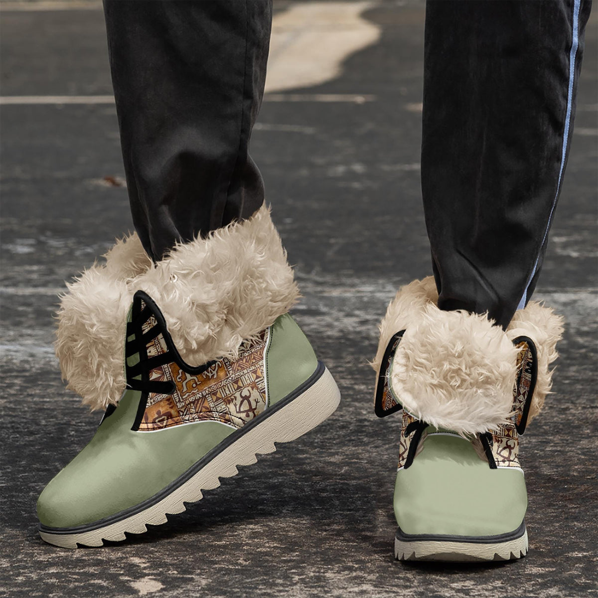 A pair of green and white furry boots with a patterned design on the side, standing on a gray surface.