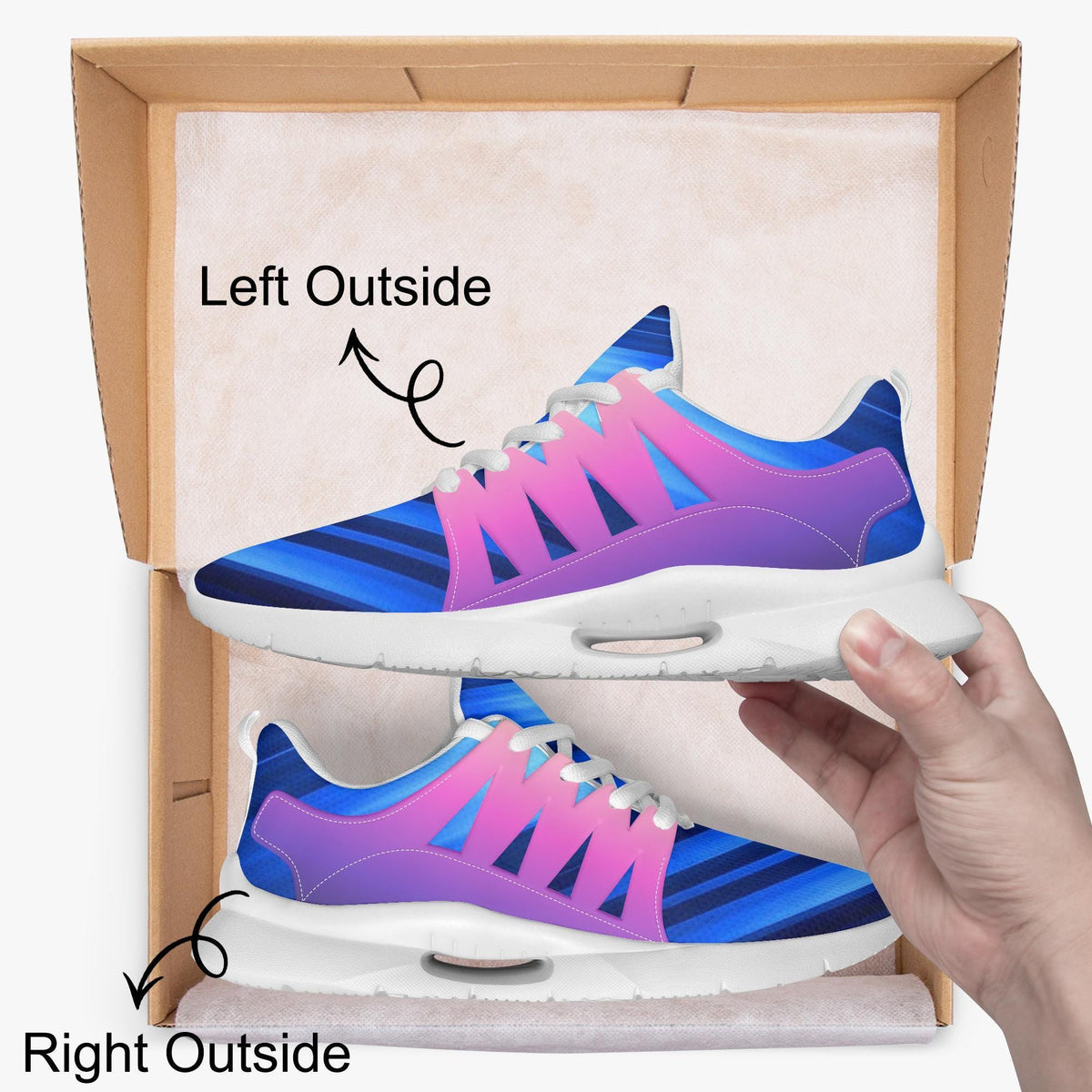 A person's hand is holding a pair of colorful sneakers, with the left shoe positioned outside the box and the right shoe inside the box.