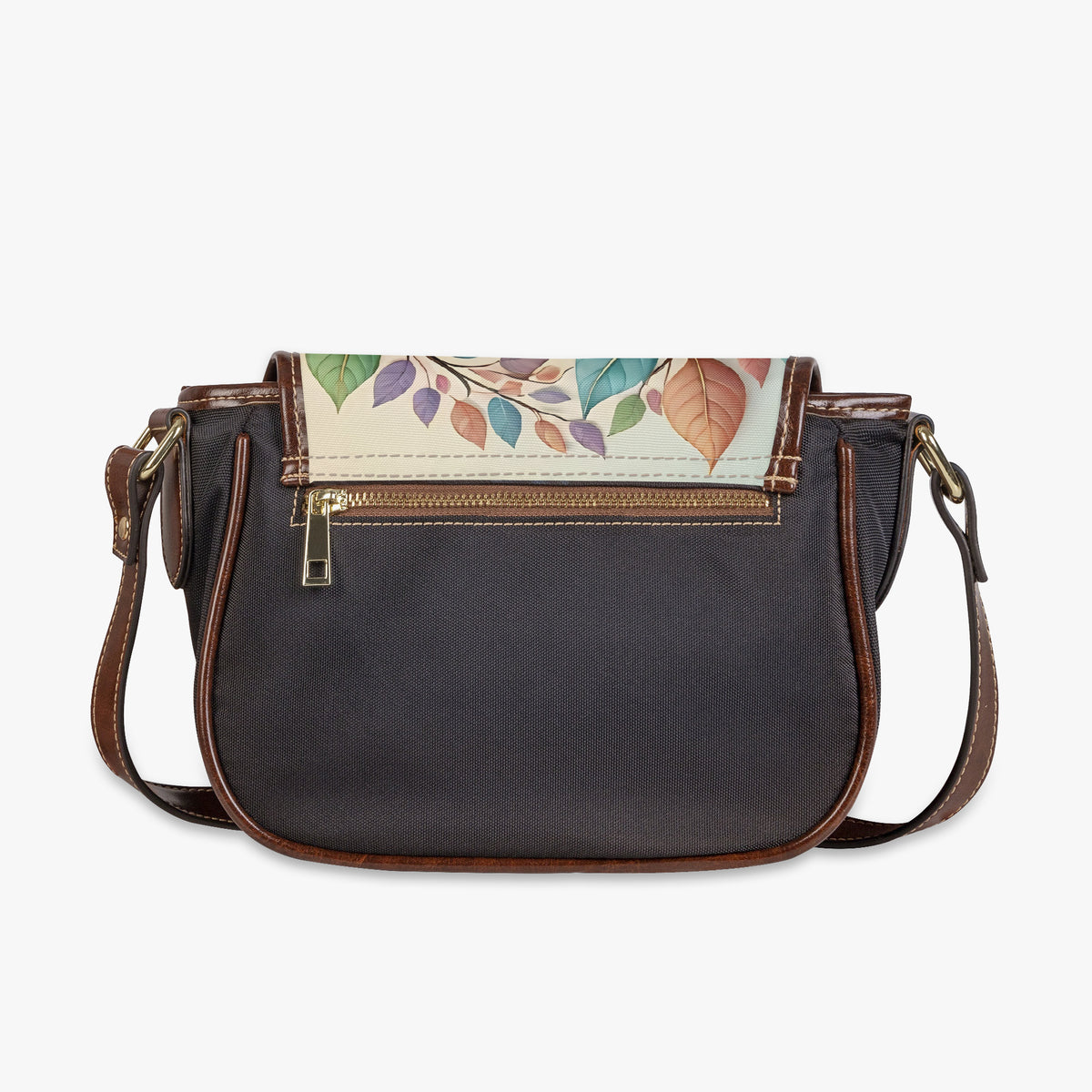 Bolso bandolera con estampado de pájaros apoyado en una silla gris junto a una revista