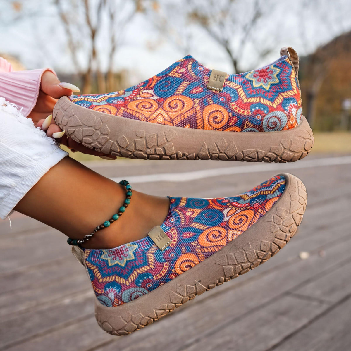 A person's feet wearing colorful patterned shoes are shown in the image.