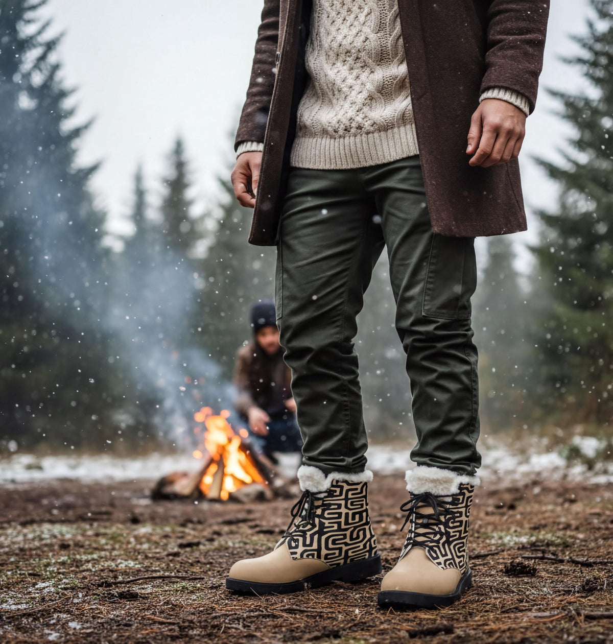 A person wearing a brown coat and patterned boots stands in a snowy forest, with a campfire visible in the background.