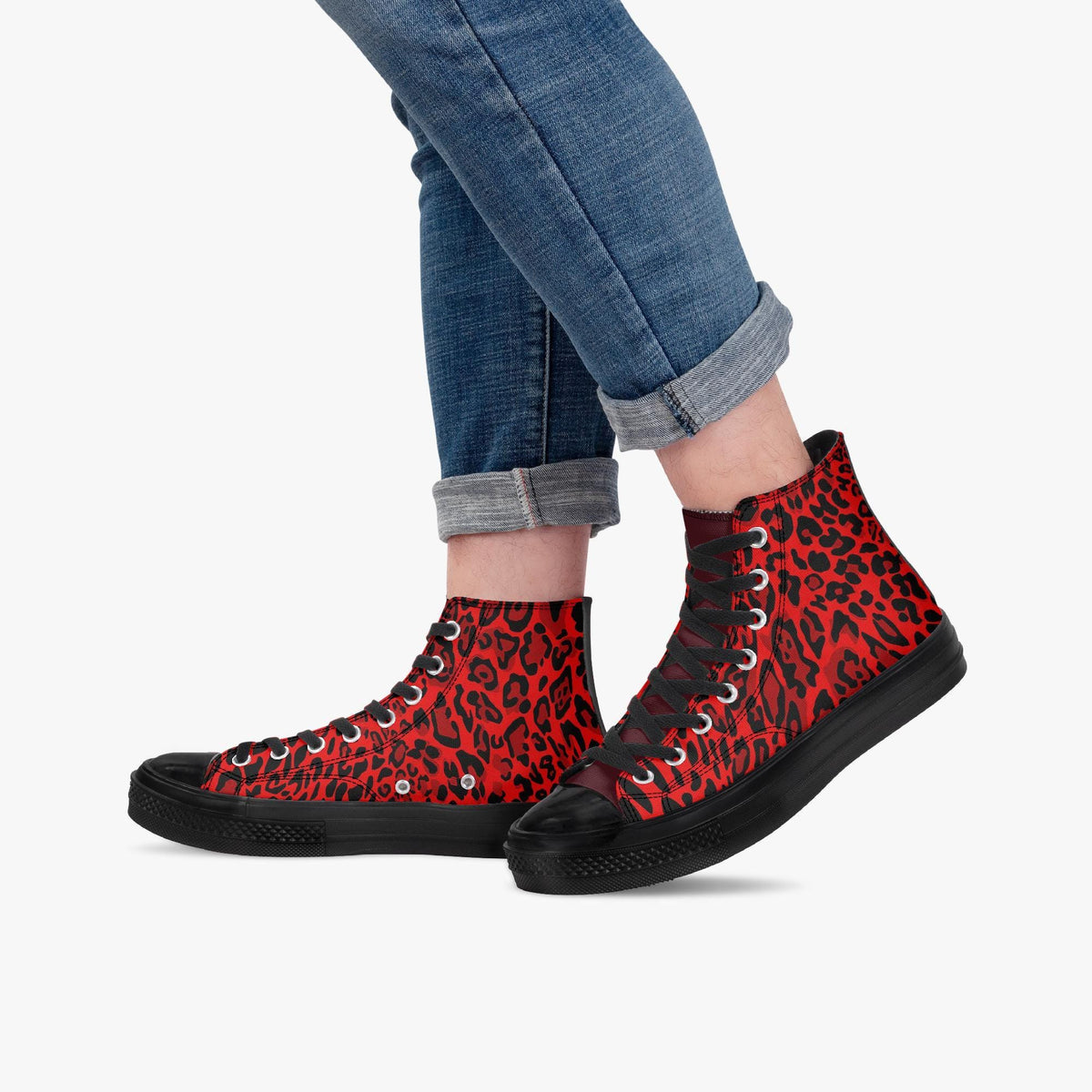A person wearing blue jeans and red high-top sneakers with a leopard print pattern.