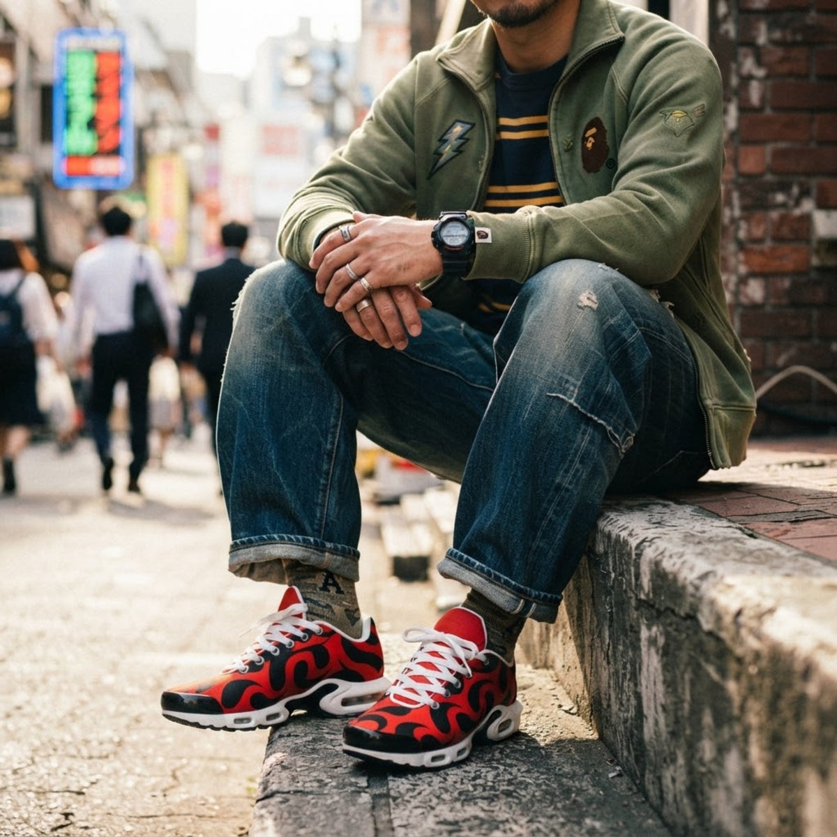 Streetstyle-Model sitzt in Jeans und Jacke und trägt rote Mesh Sneaker