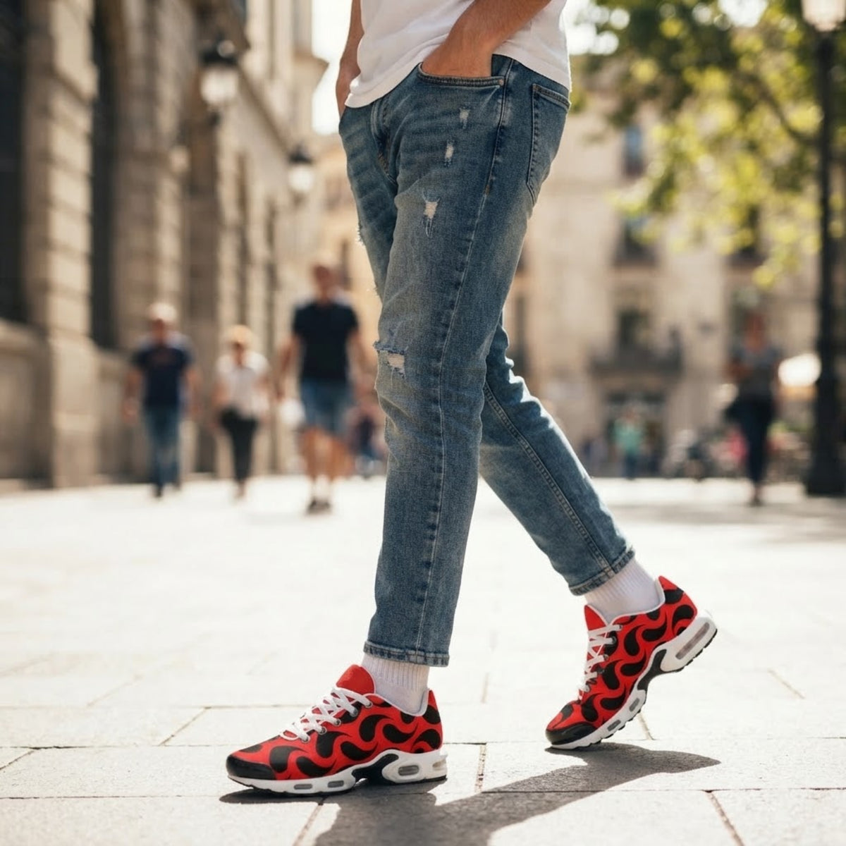 Model geht auf einer Stadtstraße und trägt rote Flammen-Print Sneaker zu Jeans