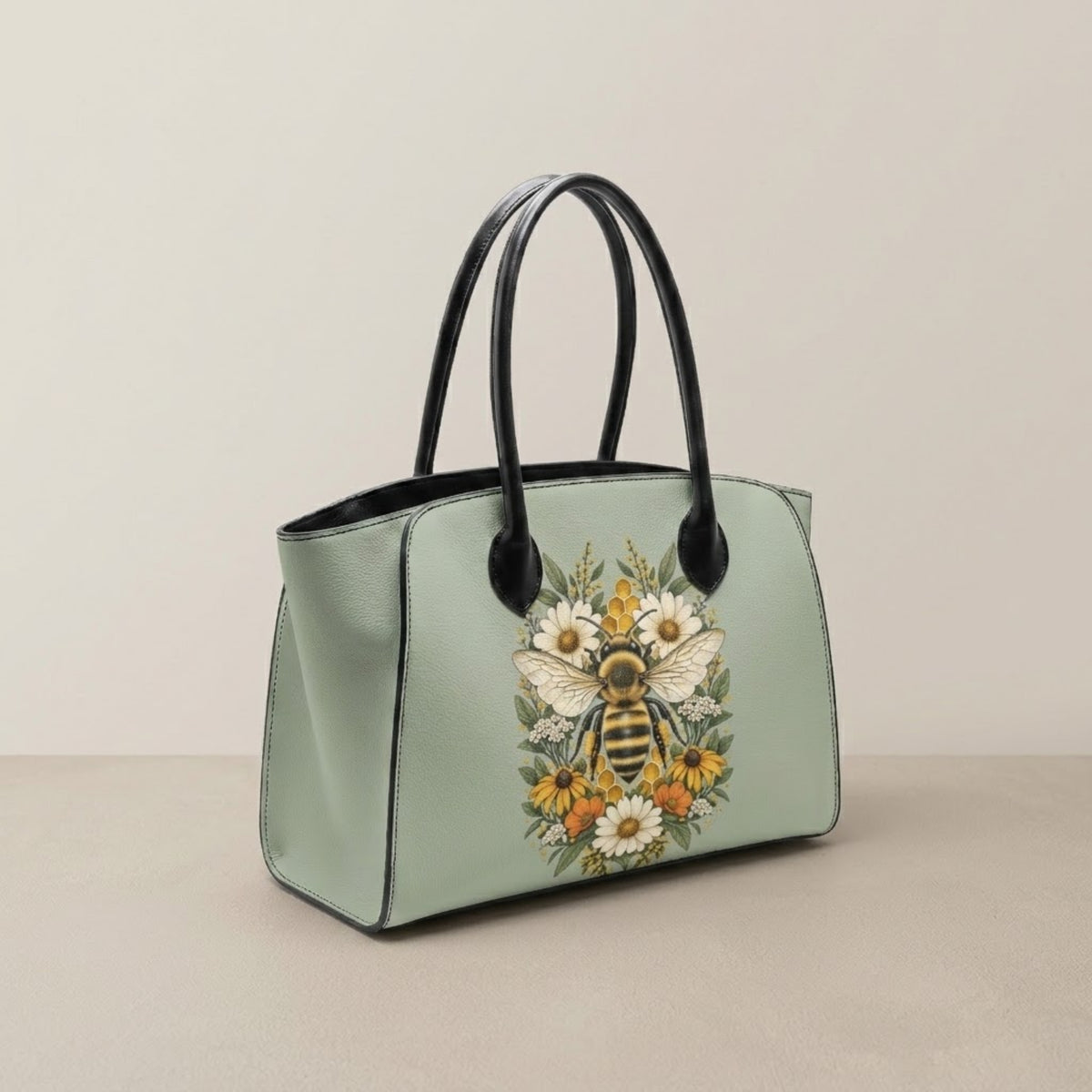 Borsa tote bee verde salvia con manici neri da avambraccio e finitura in pelle ecologica goffrata, vista frontale a tre quart