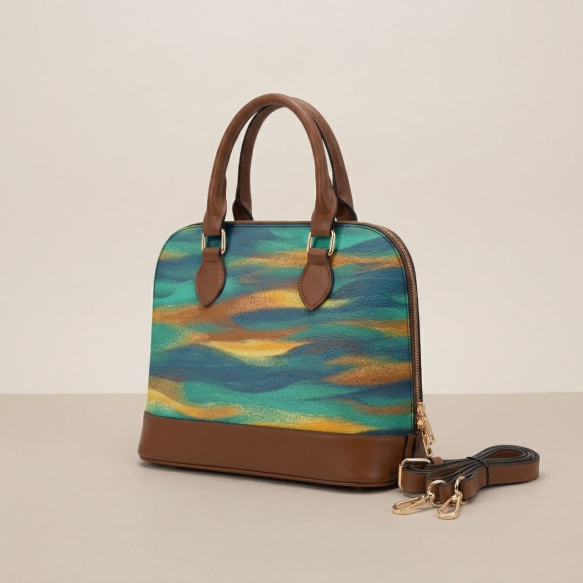 Borsa a sacca con onde astratte nelle tonalità turchese e giallo dorato, vista a tre quarti su sfondo beige