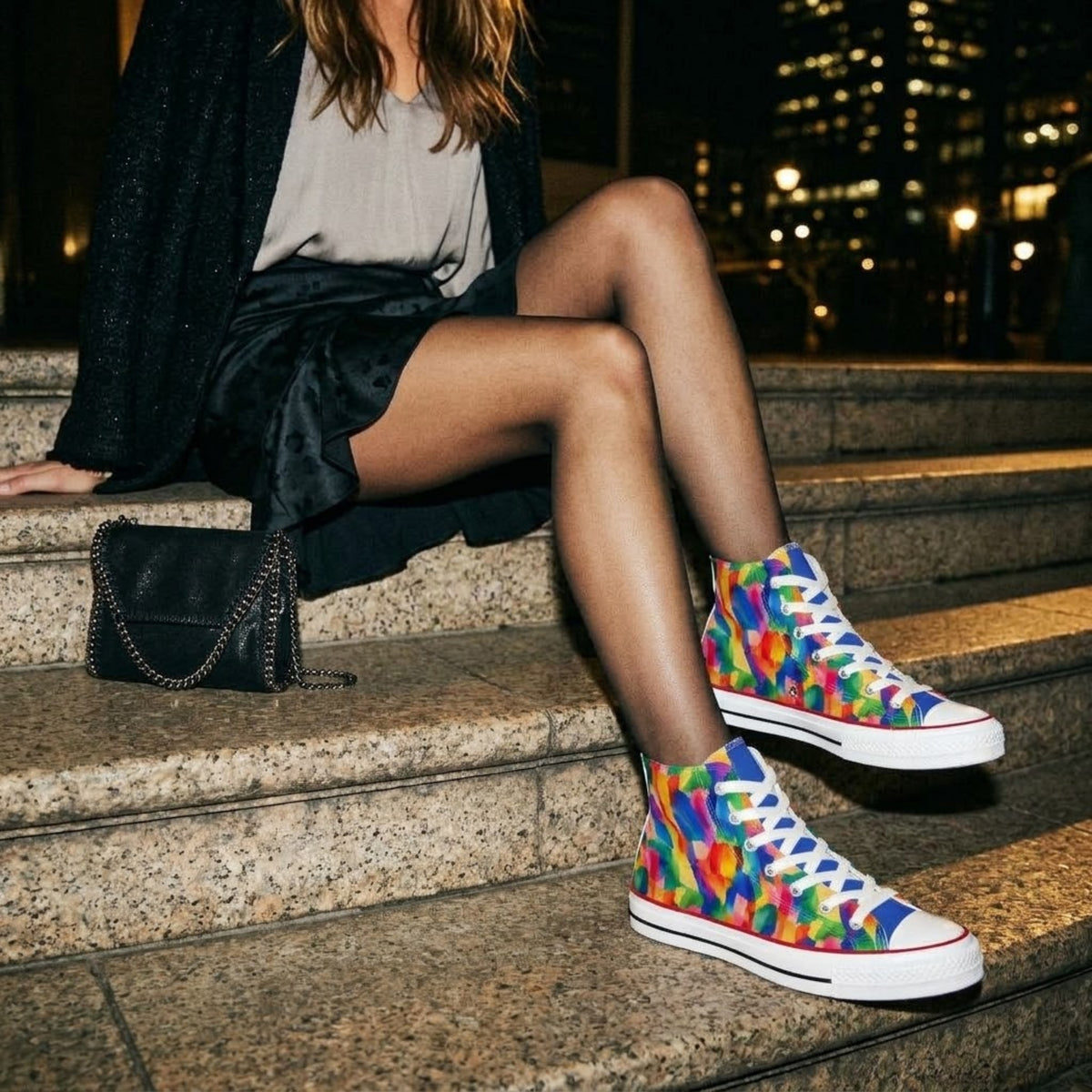 Model seated on steps wearing high top sneakers with a black handbag