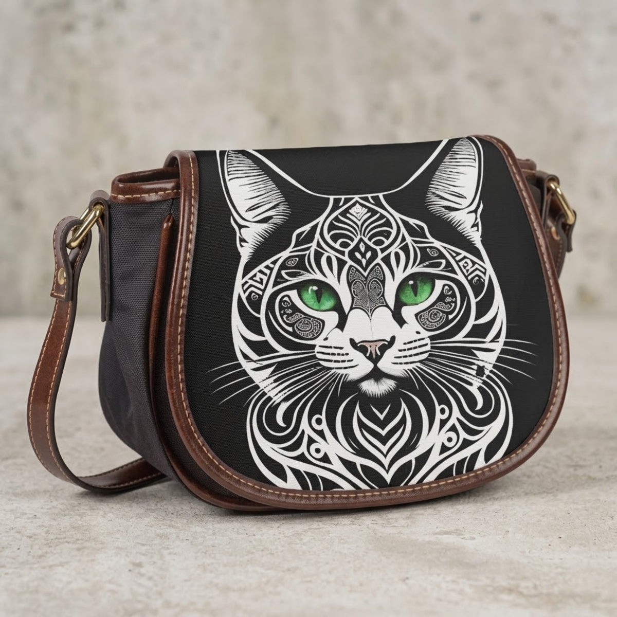 Black cat crossbody bag with white-line cat portrait and mandala design, front view on concrete background