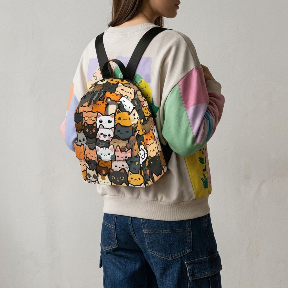 Model wearing cat print backpack over a sweatshirt, shoulder view