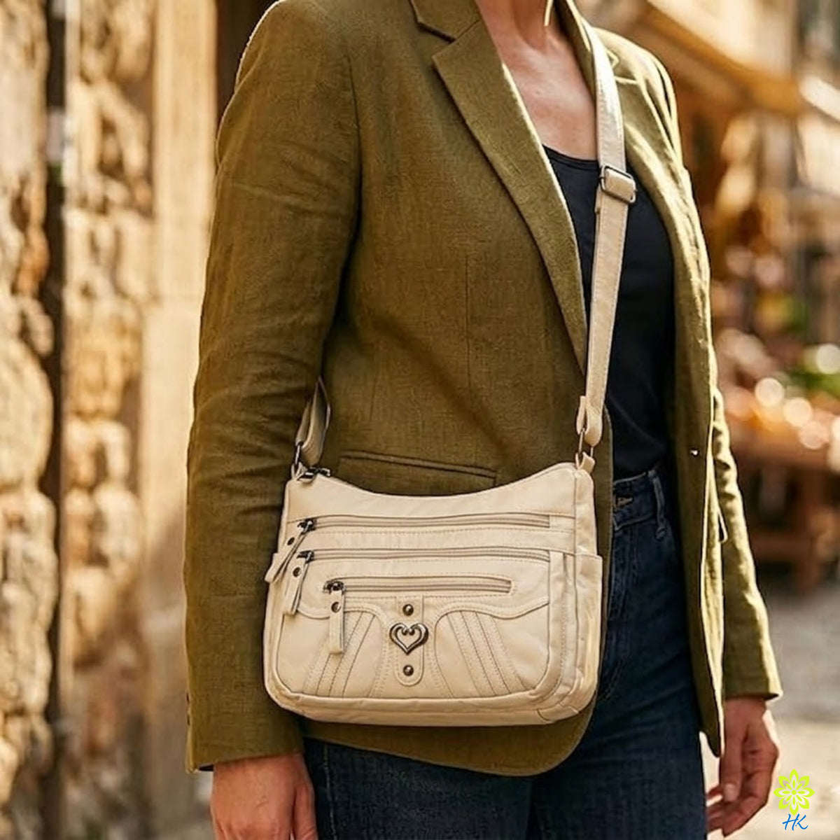 Model trägt eine Multi-Pocket-Umhängetasche als Crossbody zu einem olivgrünen Blazer auf einer Stadtstraße