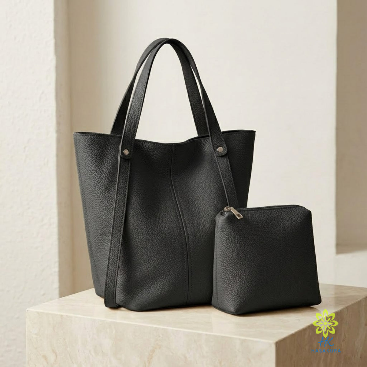 Black tote bag worn on the shoulder with a black blazer and black shorts