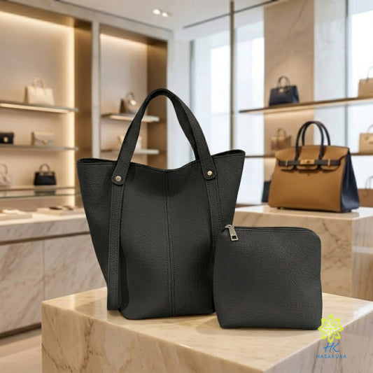 Black PU leather tote bag with matching clutch on a marble pedestal, a black tote bag set
