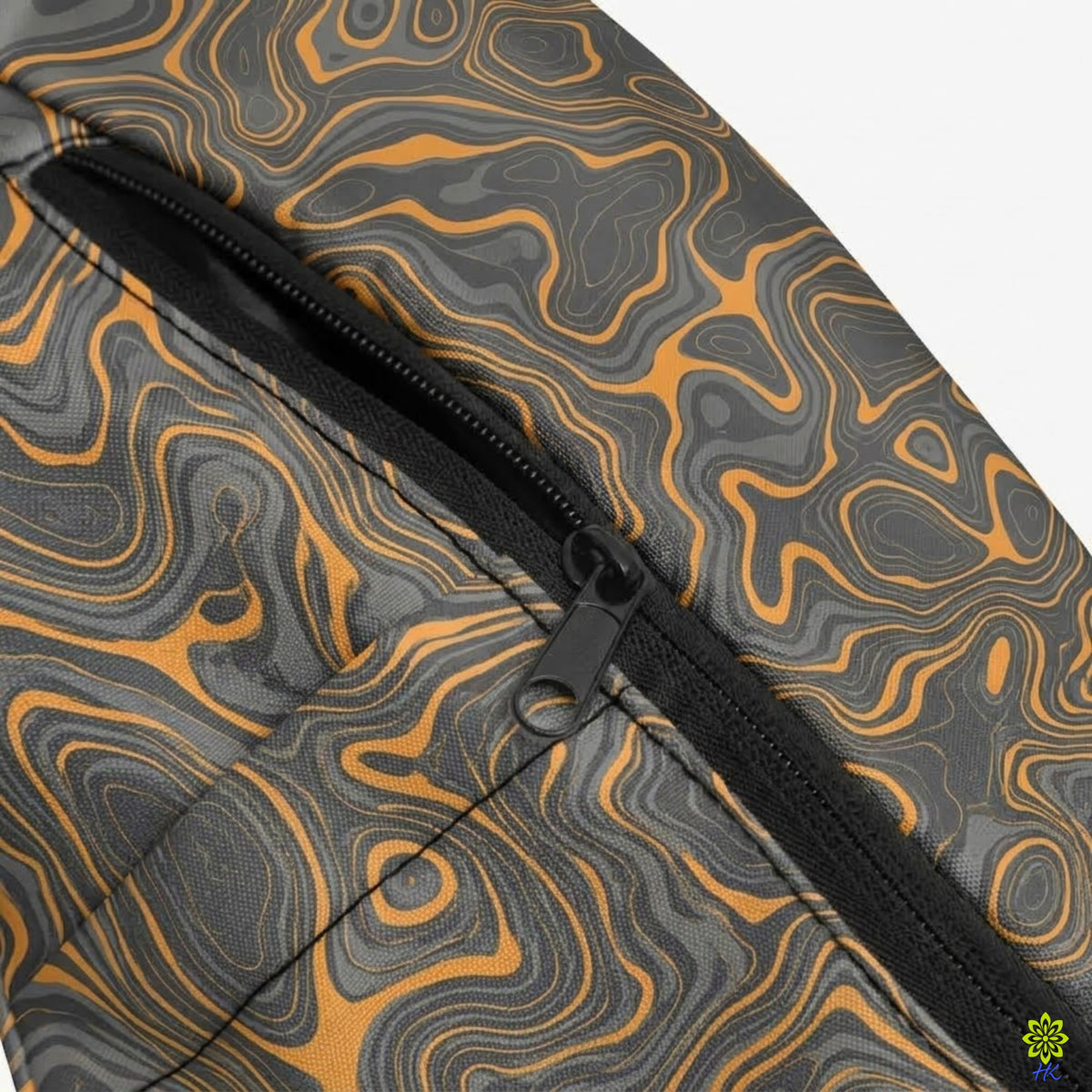 Close-up of a black zipper on a fabric surface with a gray and orange wavy topographic pattern.