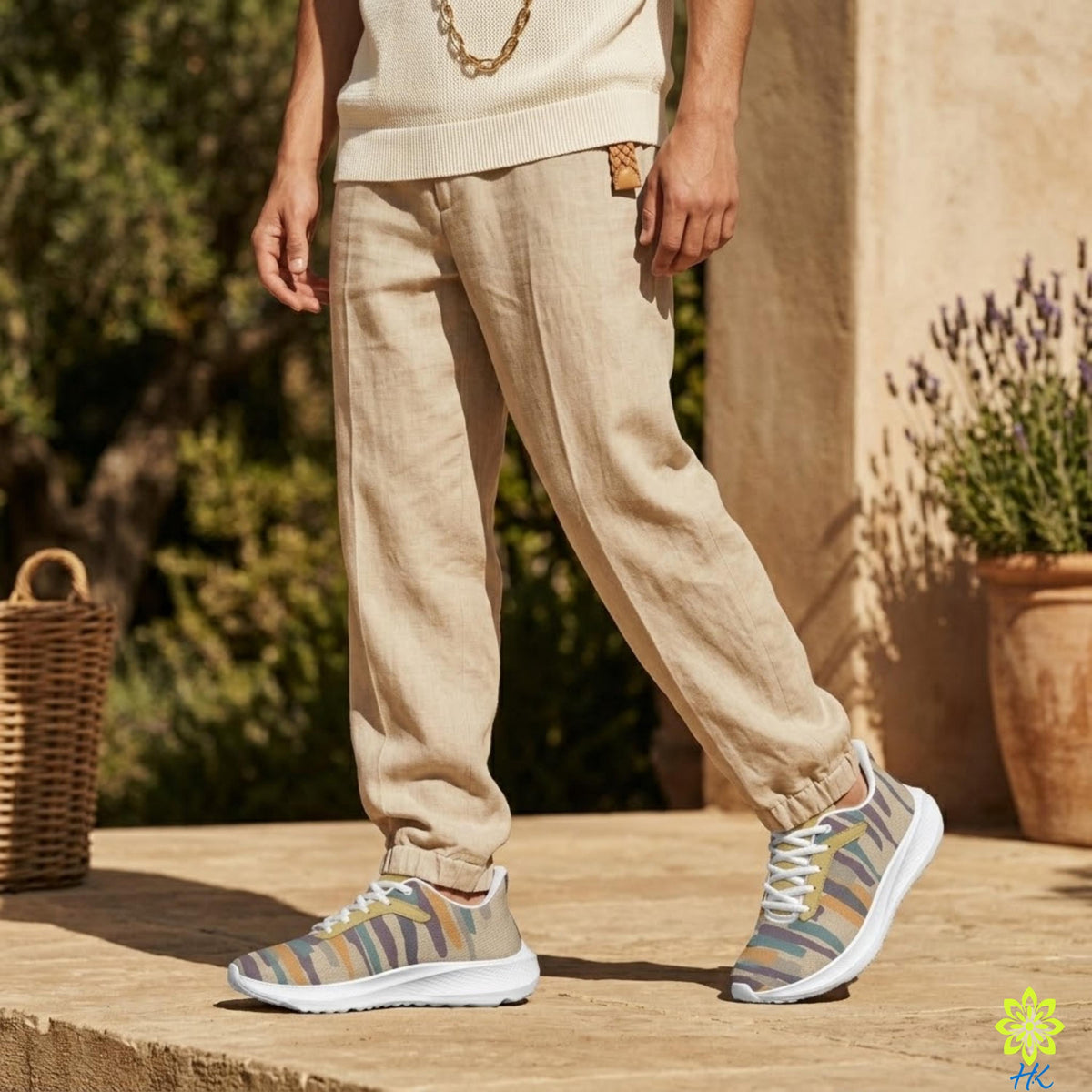 A person wearing beige pants and colorful sneakers stands on a stone surface, with a wicker basket and potted plant in the background.
