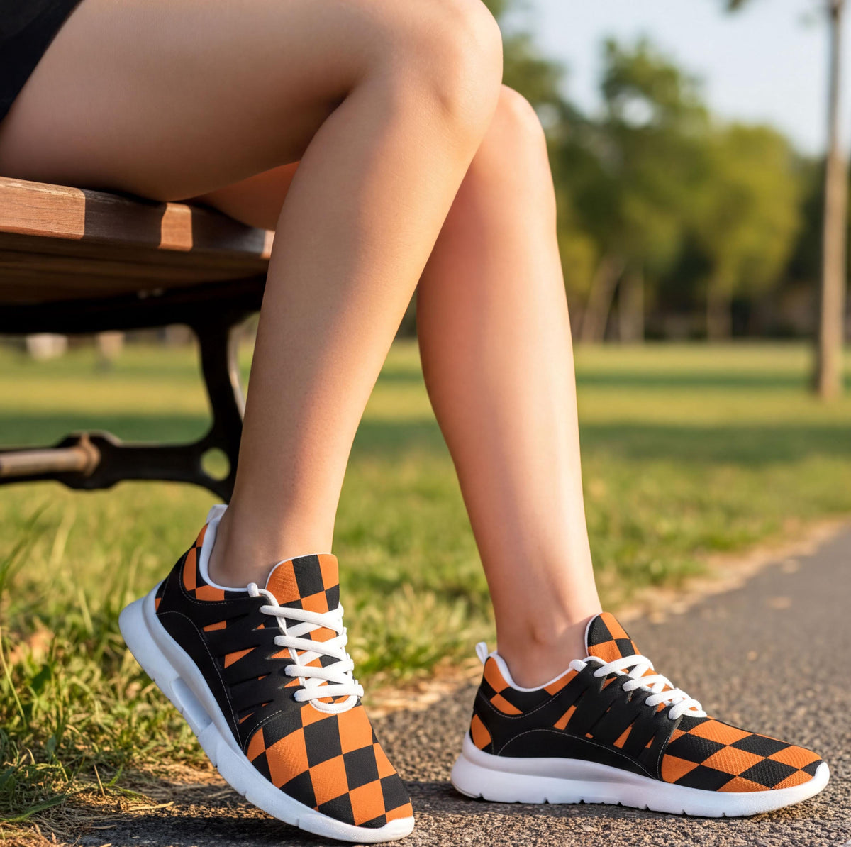 A person's legs wearing orange and black checkered sneakers are shown sitting on a bench in a park.