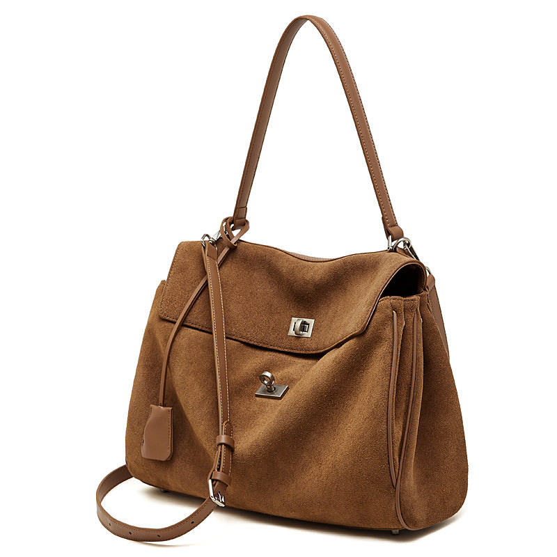 Model in linen shorts carrying a brown suede tote by its handle
