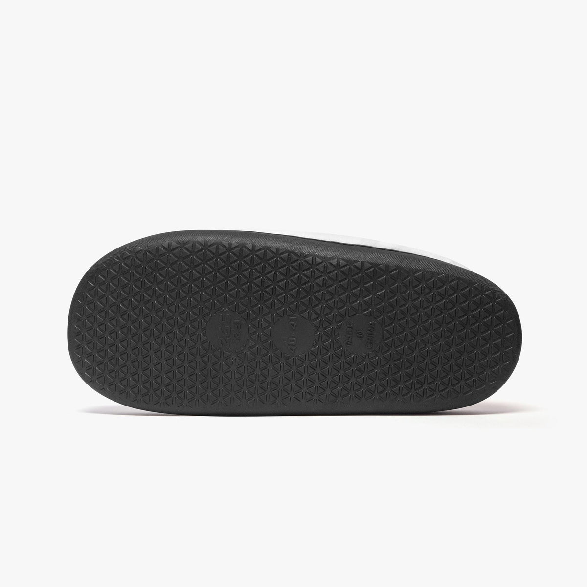 A black rubber sole of a shoe is shown against a white background.