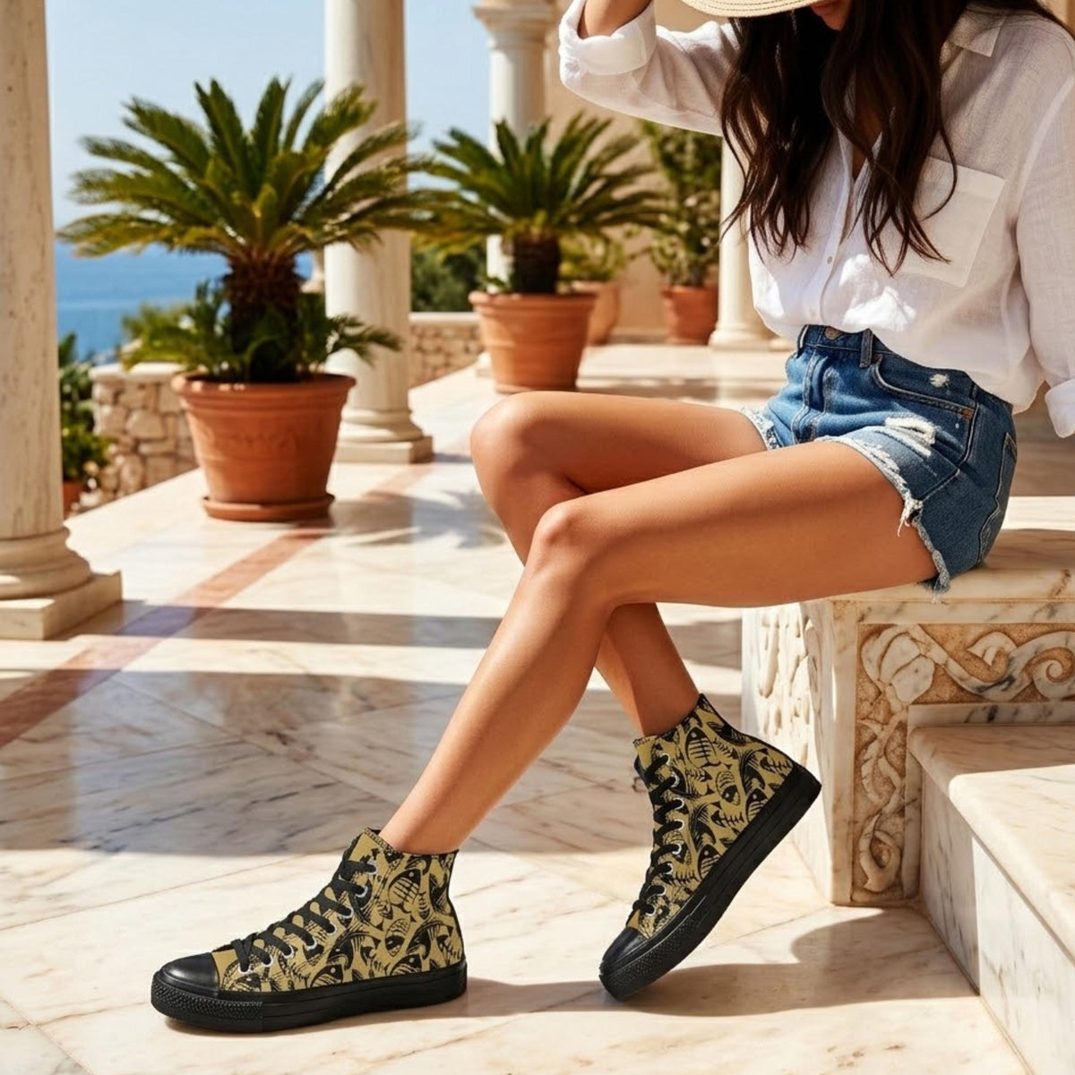 A woman wearing a white shirt and denim shorts is sitting on a stone bench, with her legs crossed and her feet resting on the bench. She is wearing a pair of high-top sneakers with a patterned design.