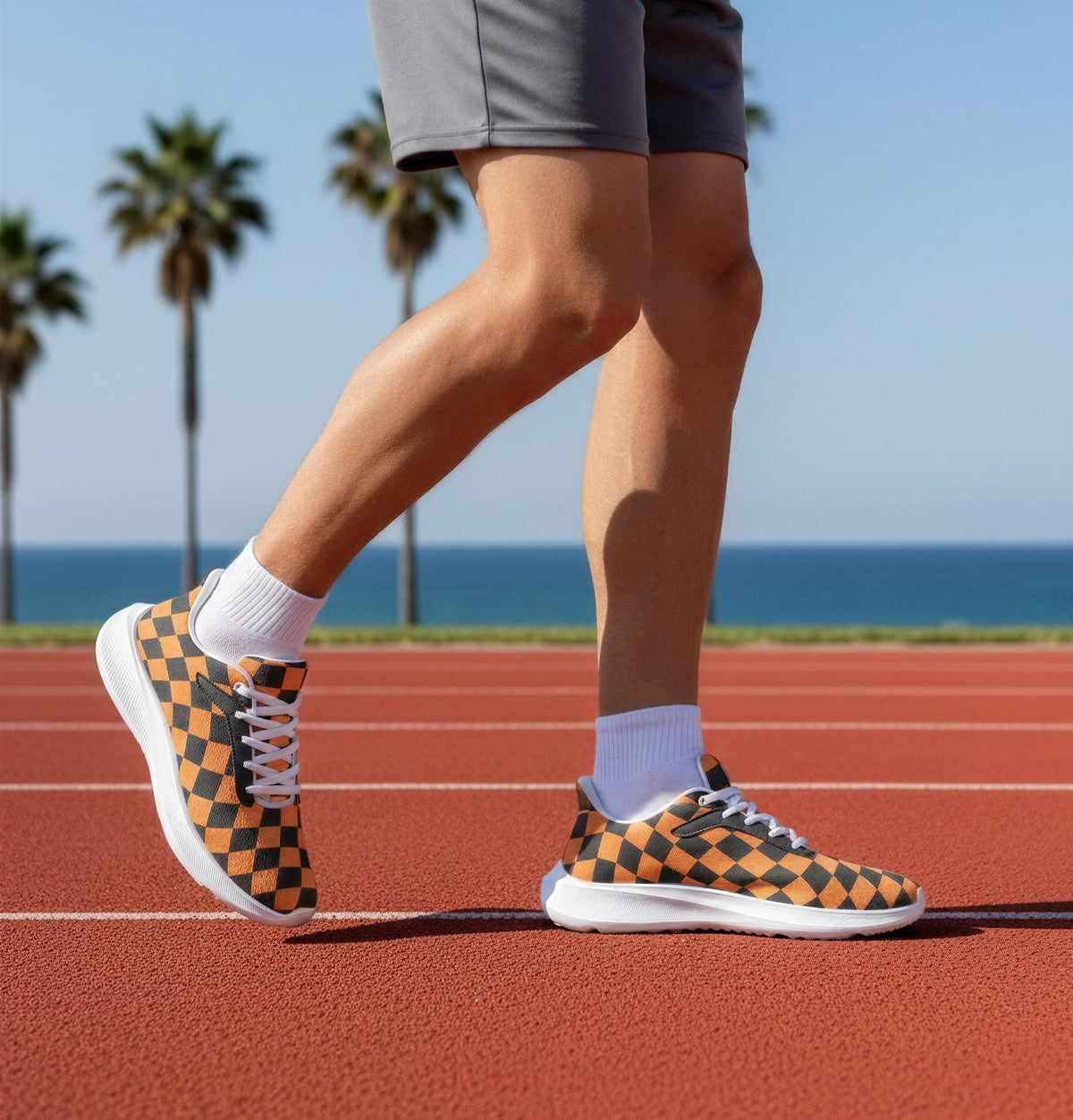 A person wearing checkered sneakers is walking on a red running track, with palm trees and a blue sky in the background.