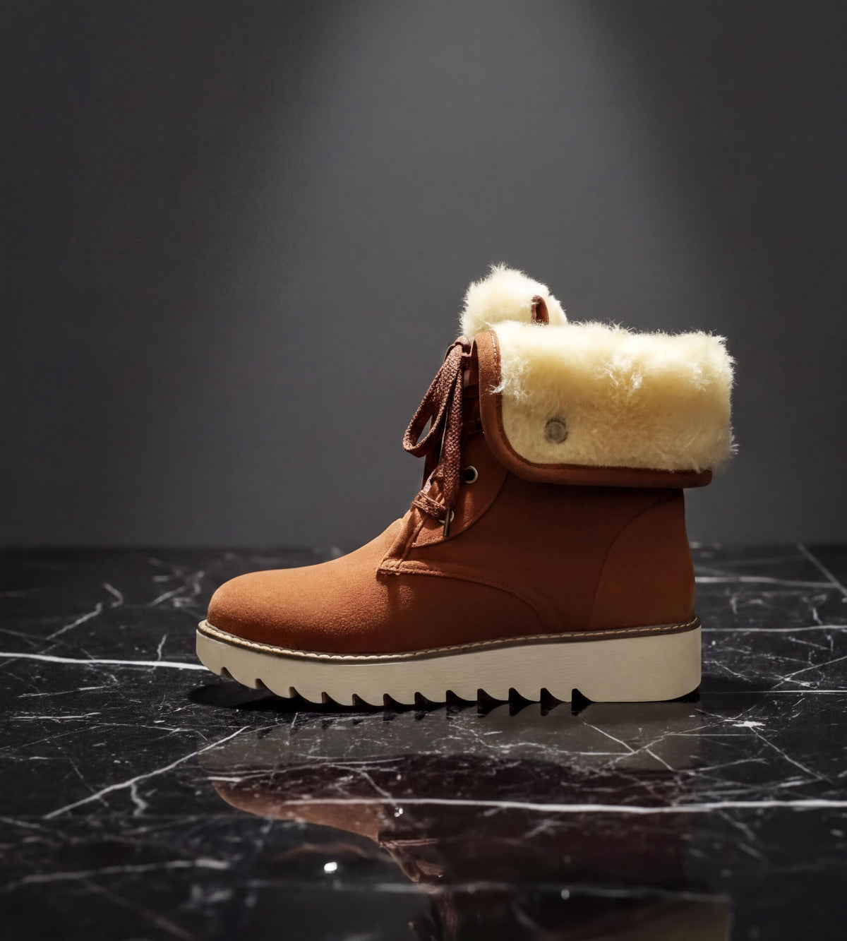 A brown leather boot with a fur lining is displayed on a black marble surface.
