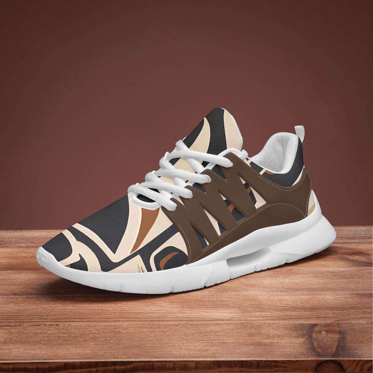A pair of brown and white patterned sneakers with white laces, displayed on a wooden surface against a red background.
