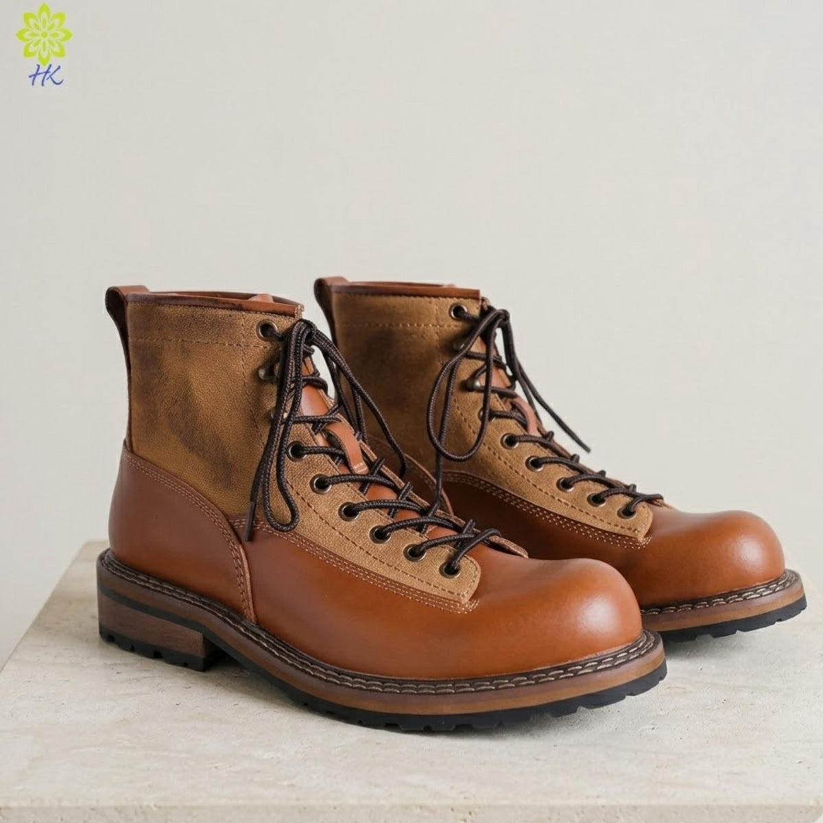 A pair of brown leather boots with laces and a rugged sole, displayed on a white surface against a plain background.