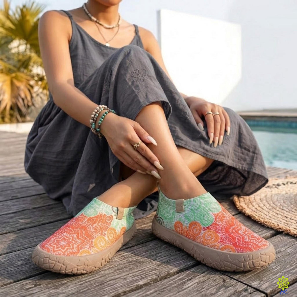 Donna seduta all'aperto che indossa scarpe slip-on a mandala con un abito grigio