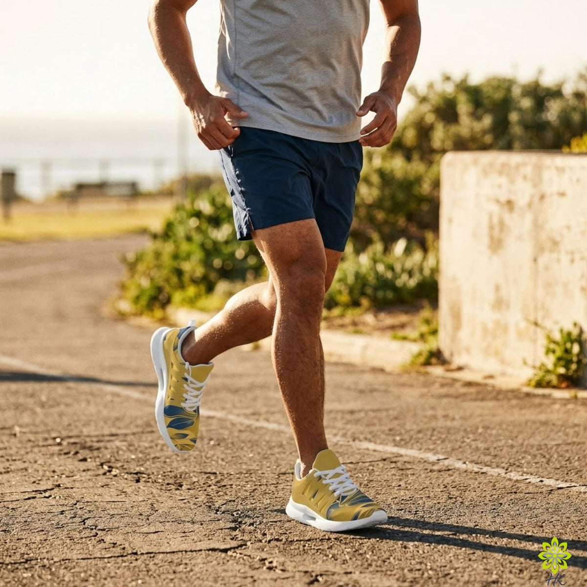 A man is jogging on a paved path, wearing blue shorts and yellow running shoes.